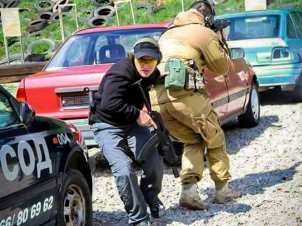 Two cadets armed with machine guns during firing practice among a standing passenger vehicle at a training ground in Bulgaria